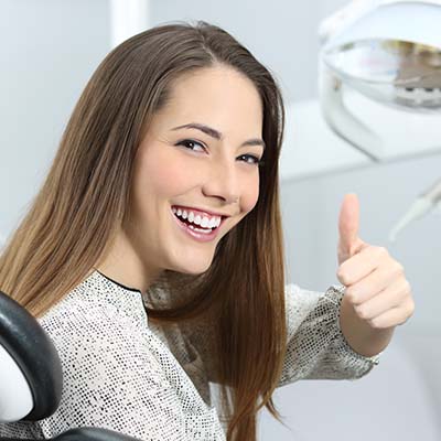 Frau auf dem Zahnarztstuhl, die zufrieden ist